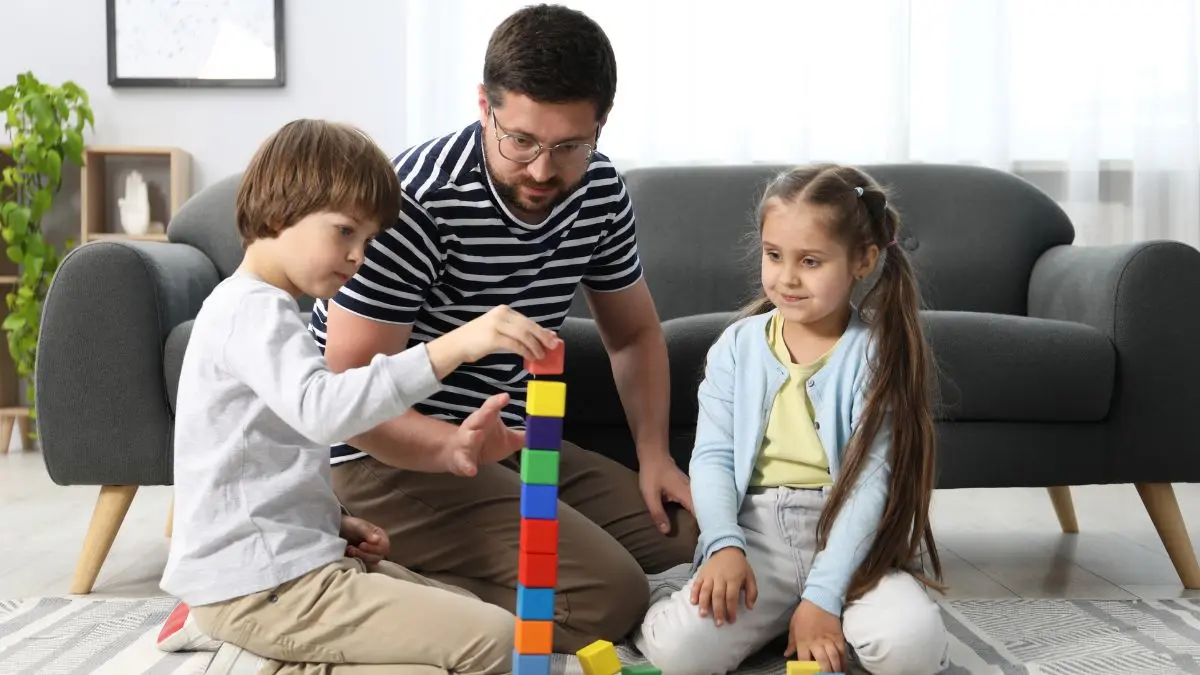 father-and-children-building-colorful-block-tower-together-at-home