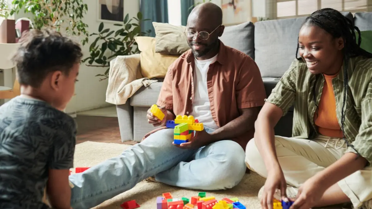 parents-and-child-playing-with-building-blocks-on-living-room-floor