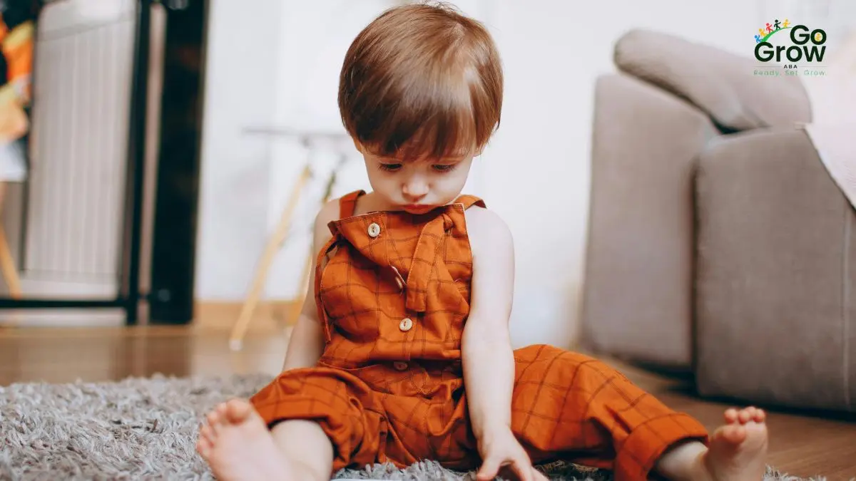 toddler-sitting-quietly-on-floor-in-home-setting