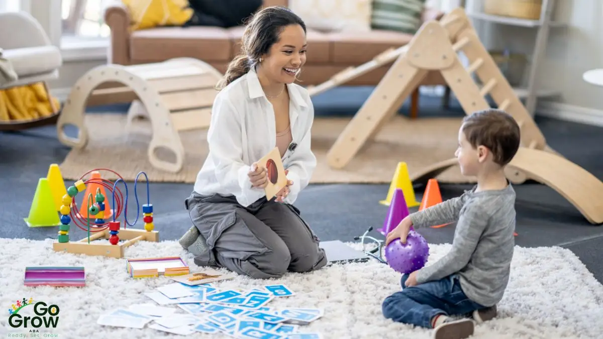 child-and-therapist-playing-with-cards-and-toys-on-rug