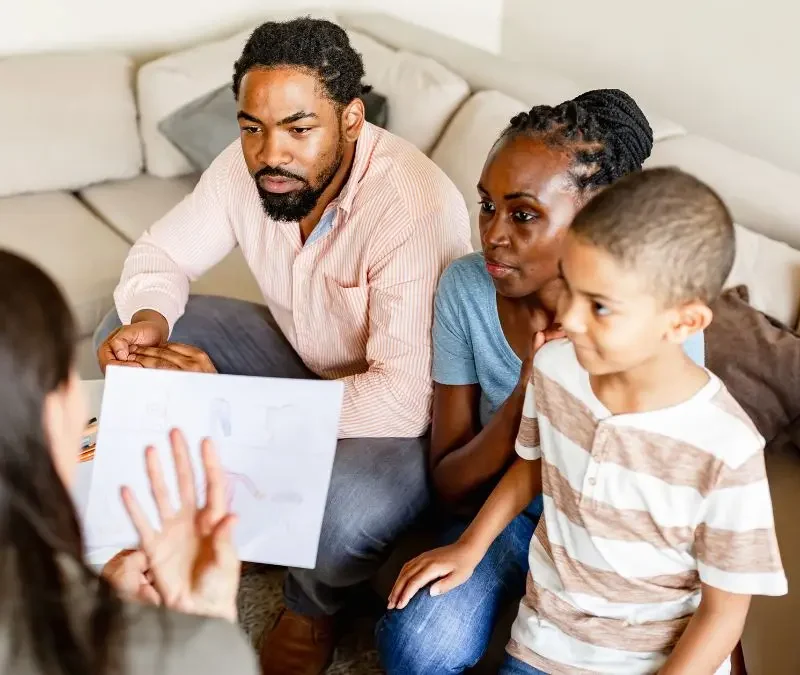 family-meeting-with-woman-showing-paper-in-living-room