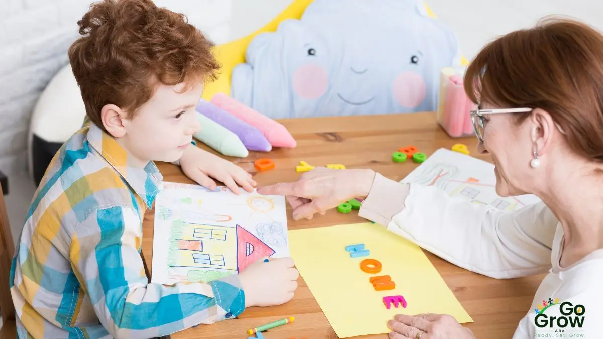 woman-pointing-to-childs-drawing-during-table-activity