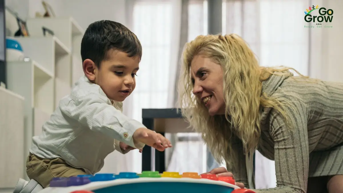 woman-smiling-at-child-playing-with-colorful-toy