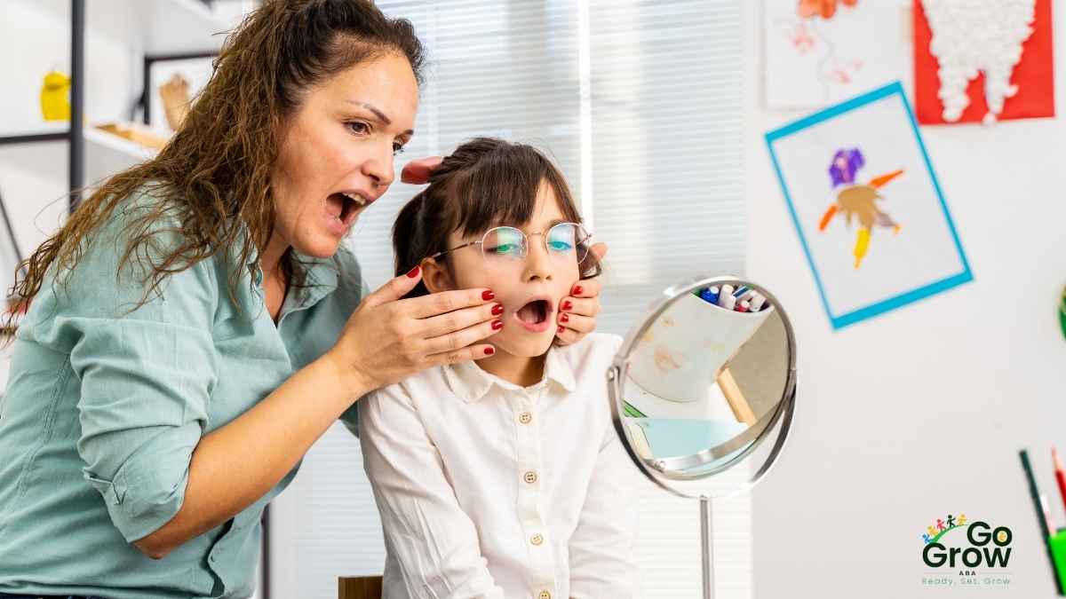 Therapist guiding a child to practice mouth movements using a mirror during a therapy session