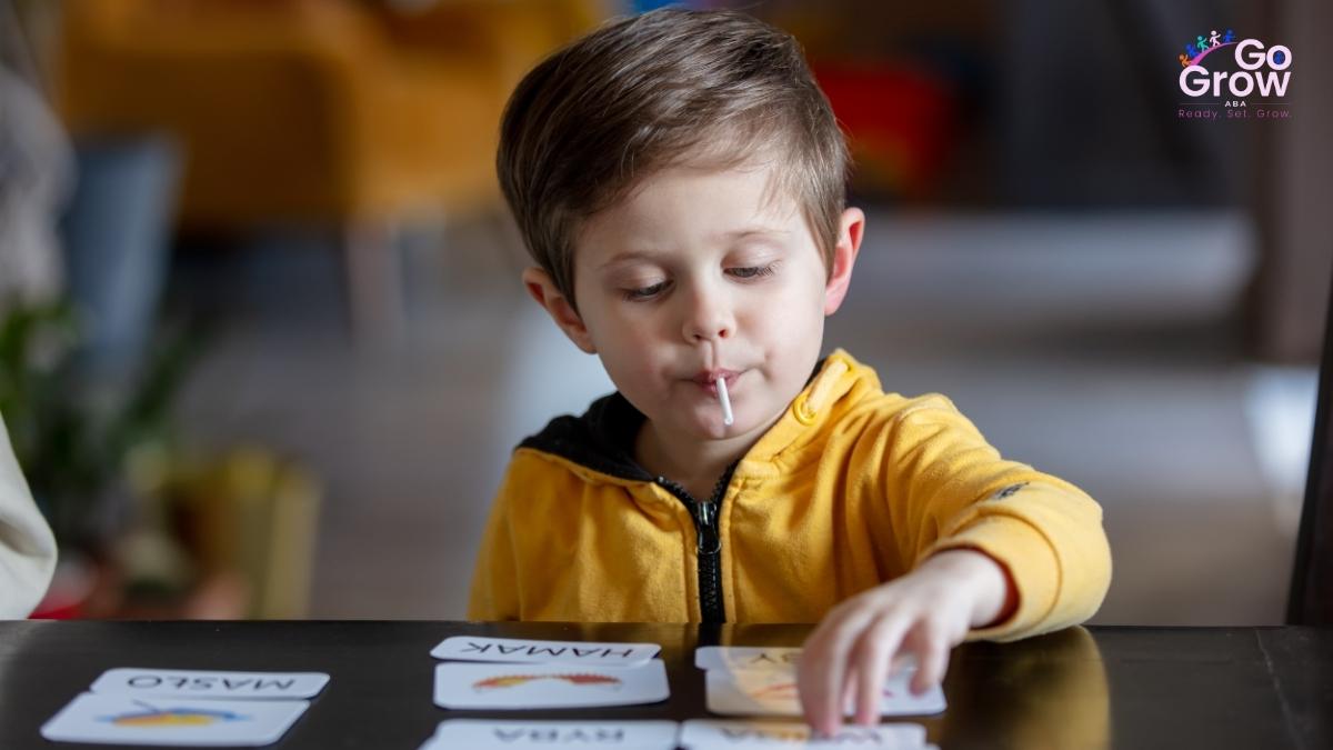 Young boy playing a card matching game during a therapy session